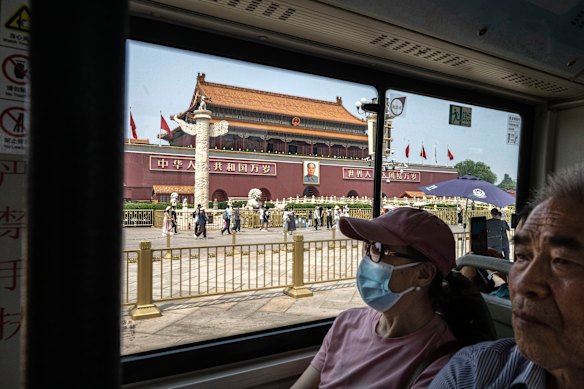 People ride a public bus past Tiananmen Gate in Beijing. Trump’s last visit to China was in 2017. 