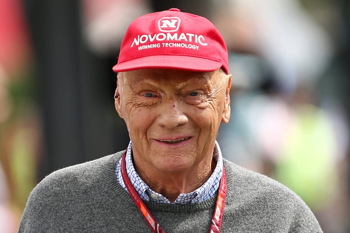 Niki Lauda smiles wearing his famous red cap