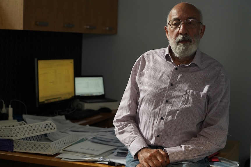 Climate scientist Bill Hare sits on his desk in Fremantle