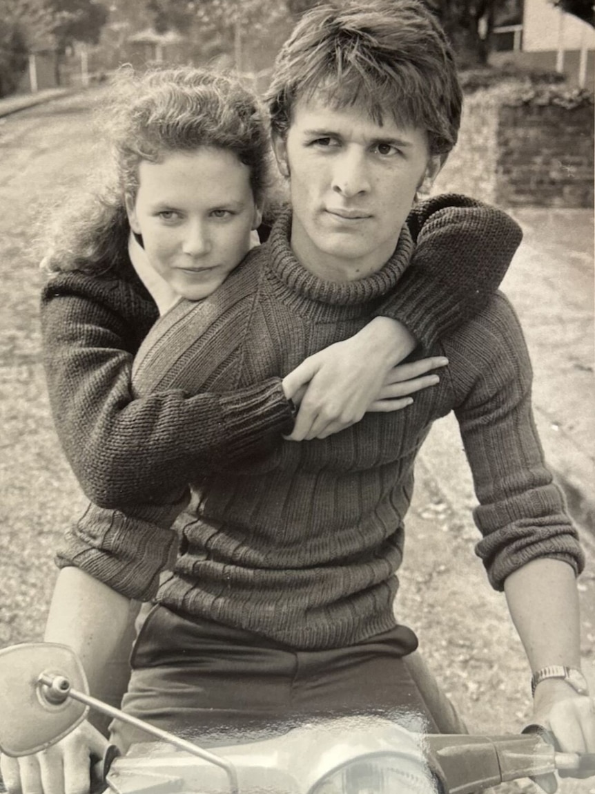 Black and white photo of Nicole Kidman with arms around John Polson.