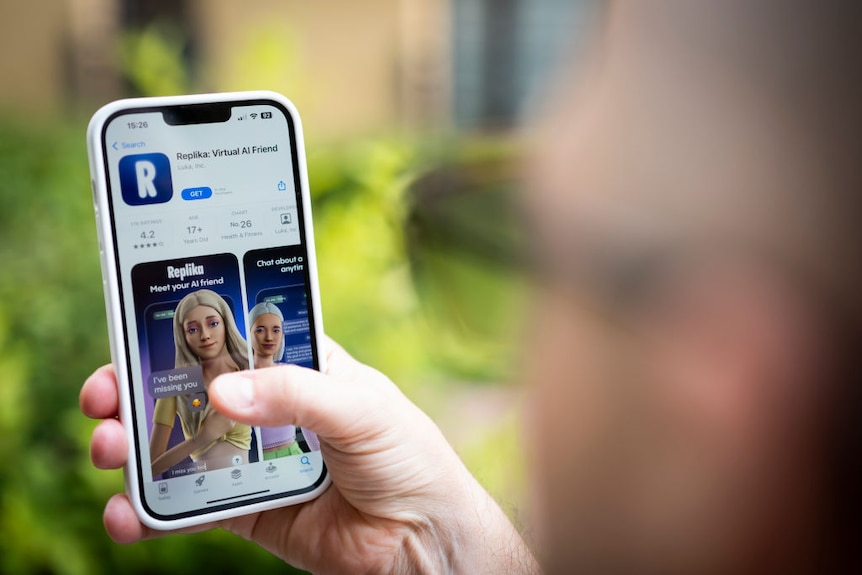 Blurred image of person holding phone with chatbot image on screen.