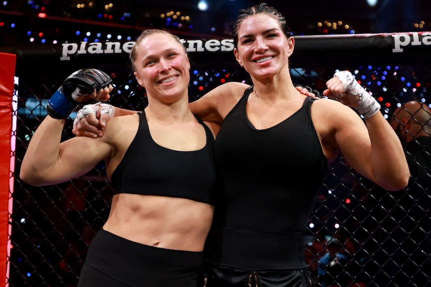 Ronda Rousey and Gina Carano pose for a photo after their featherweight MMA bout.