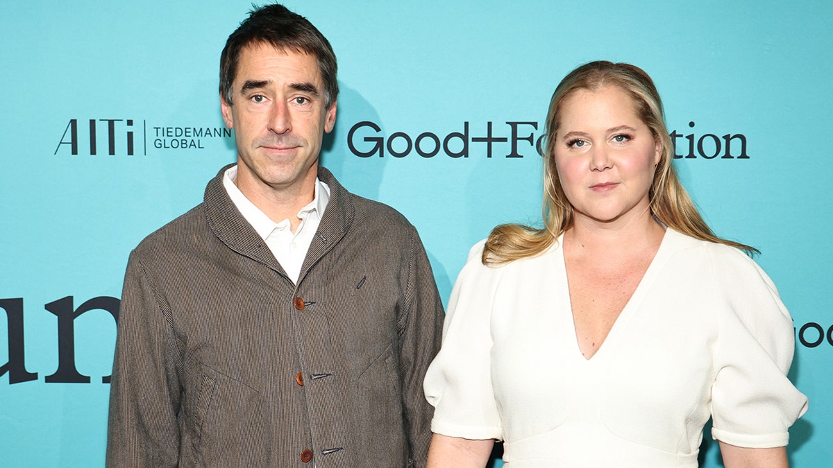 Chris Fischer and Amy Schumer walking a red carpet at Carnegie Hall