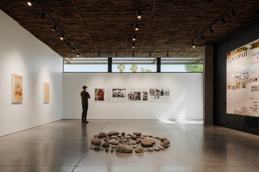 A woven willow lattice covers the ceiling of a gallery