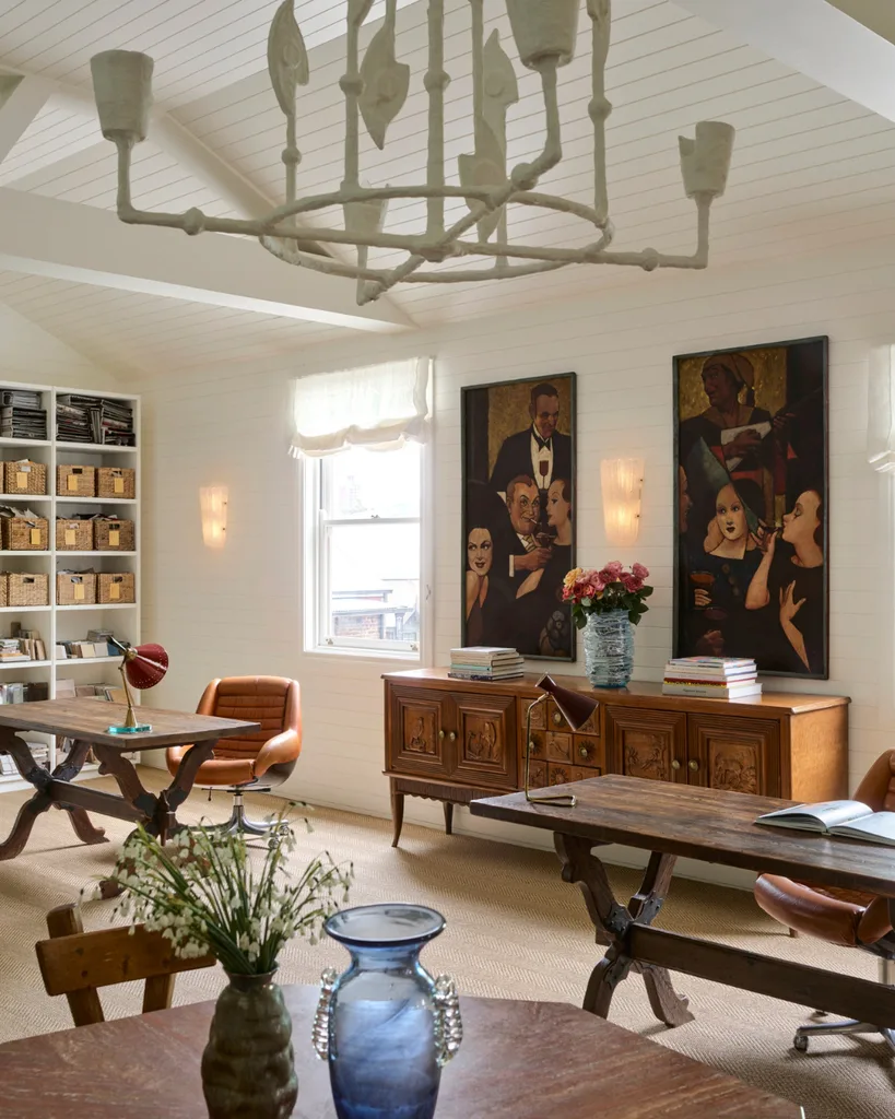A timber sideboard, abstract art, ceramic chandelier, leather armchair and bookshelf