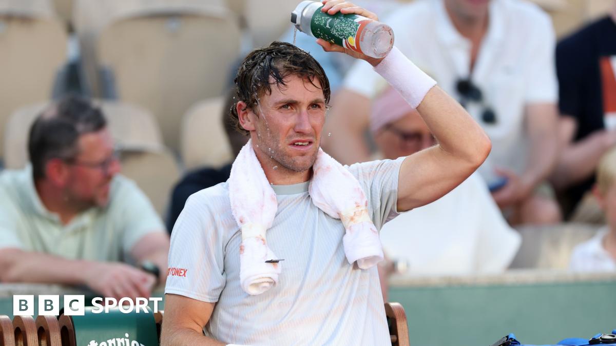 Casper Ruud pours water over his head during a change of ends