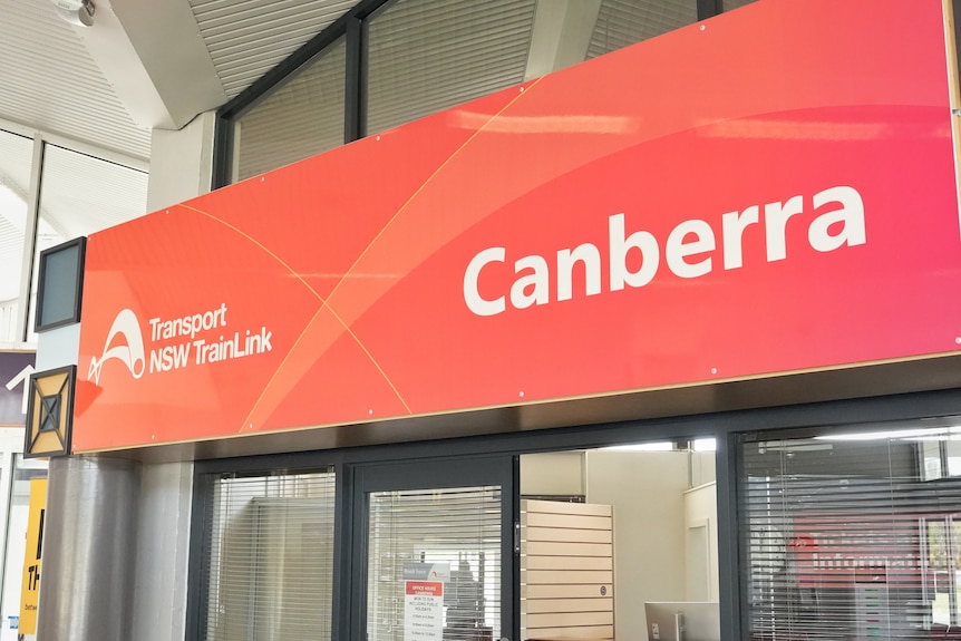 An orange sign saying 'Canberra' and also 'Transport NSW TrainLink'.