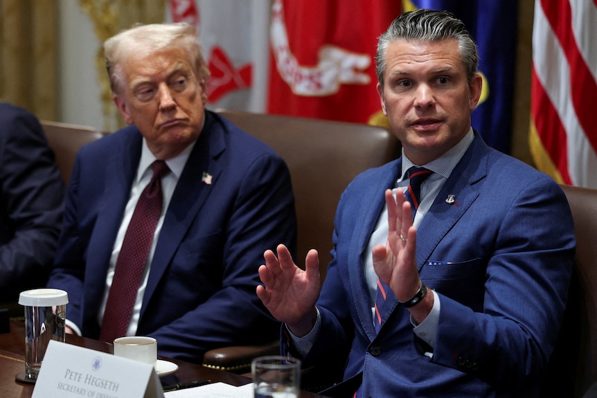 Donald Trump and Pete Hegseth sit side by side in the white house.