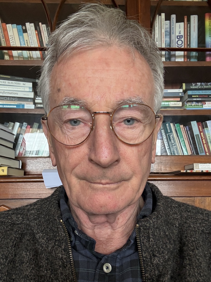 A man sitting in front of a bookcase