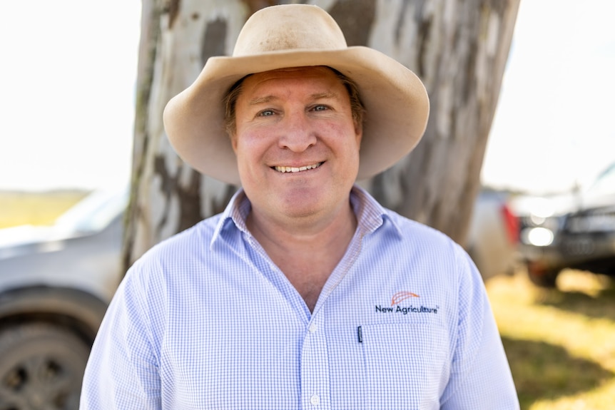A man in an Akubra hat smiling at the camera.