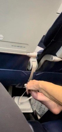A passenger picking at their feet.