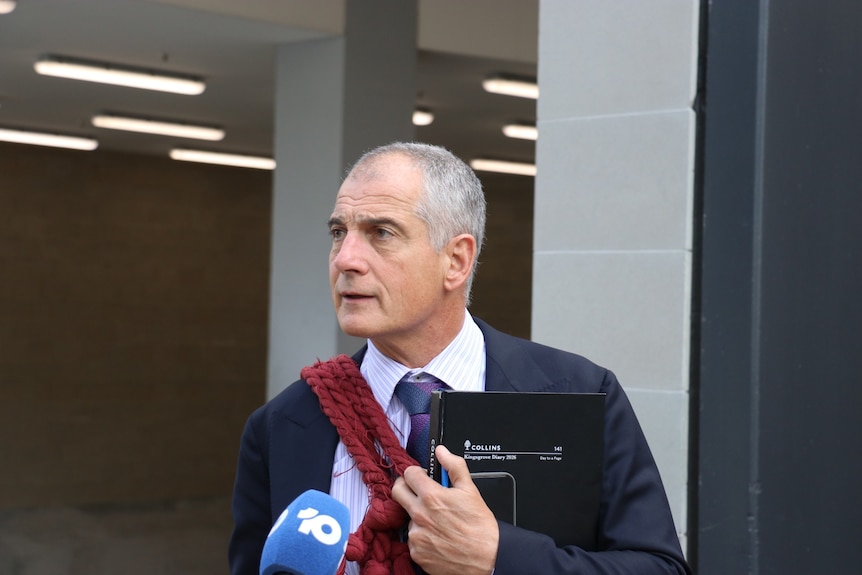 A lawyer speaks to reporters outside court