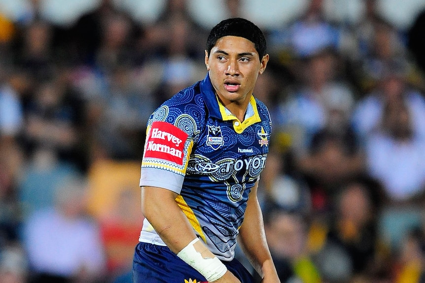 Jason Taumalolo looks on during his NRL debut. Background blurred, crowds can be seen.