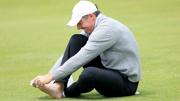 Rory McIlroy of Northern Ireland replaces his sock after checking on his blister on his toe on the 18th hole during his practice round prior to the PGA Championship at Aronimink Golf Club on May 13, 2026 in Newtown, Pennsylvania. (Photo by David Cannon/Getty Images)