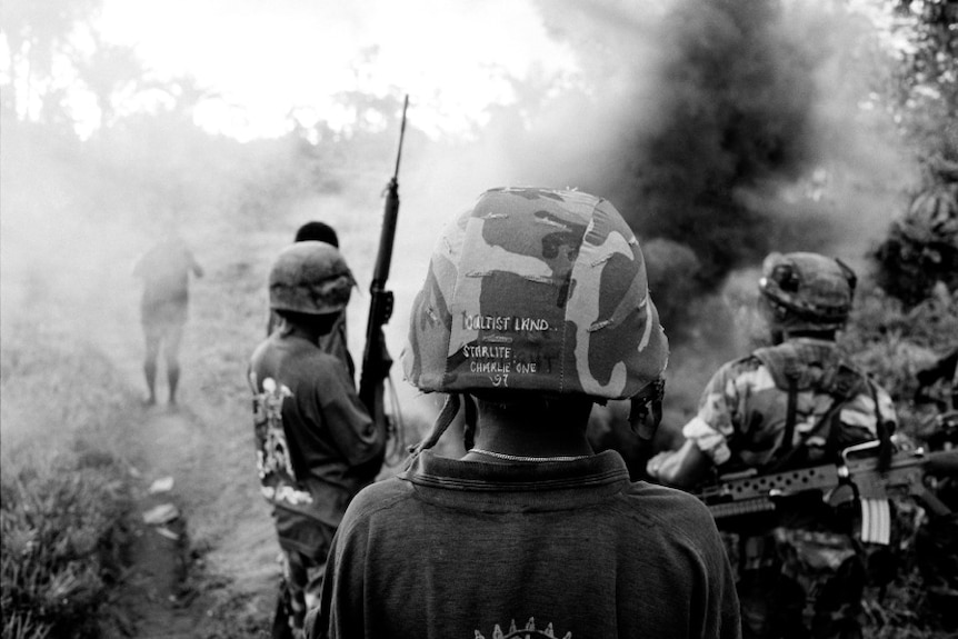 An archive photo of Bougainville's civil war with men in helmets with guns.