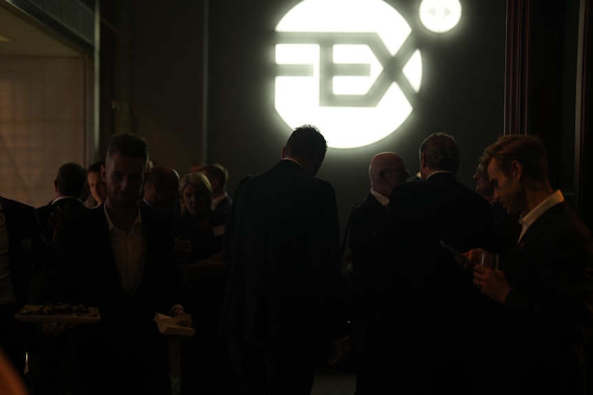 The logo for FEXGlobal lit up in a dark room.
