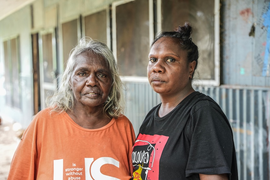 Two Aborignal women side by side looking at camera
