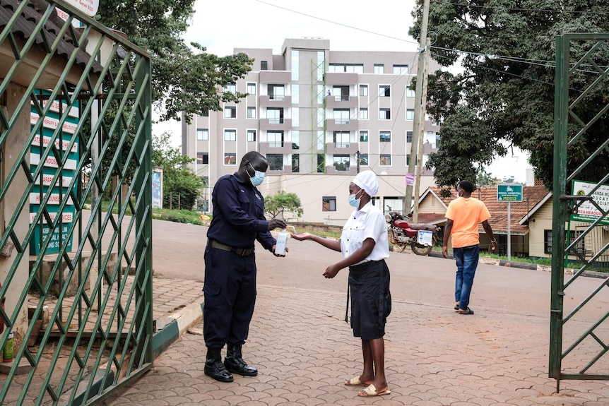 A woman sanitises her hands in front of Kibuli Muslim Hospital in Kampala, Uganda.