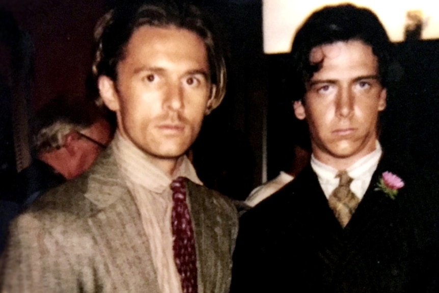 John Polson and Ben Mendelsohn in jackets and ties. They have serious expressions.