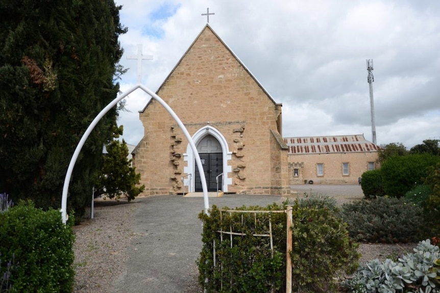 A stone church with a pointy arch in front of its entrance