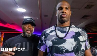 Don Charles (left) wearing a black t-shirt and baseball cap is next to Daniel Dubois (right) who is wearing a patchwork white, black and purple t-shirt