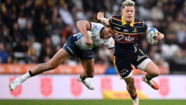 Caleb Tangitau of the Highlanders evades Joseph-Aukuso Suaalii of the NSW Waratahs.