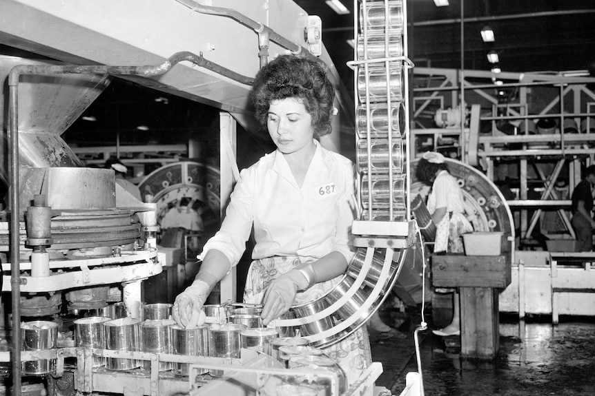 Black and white photo of a Greek woman working on a canning production line.