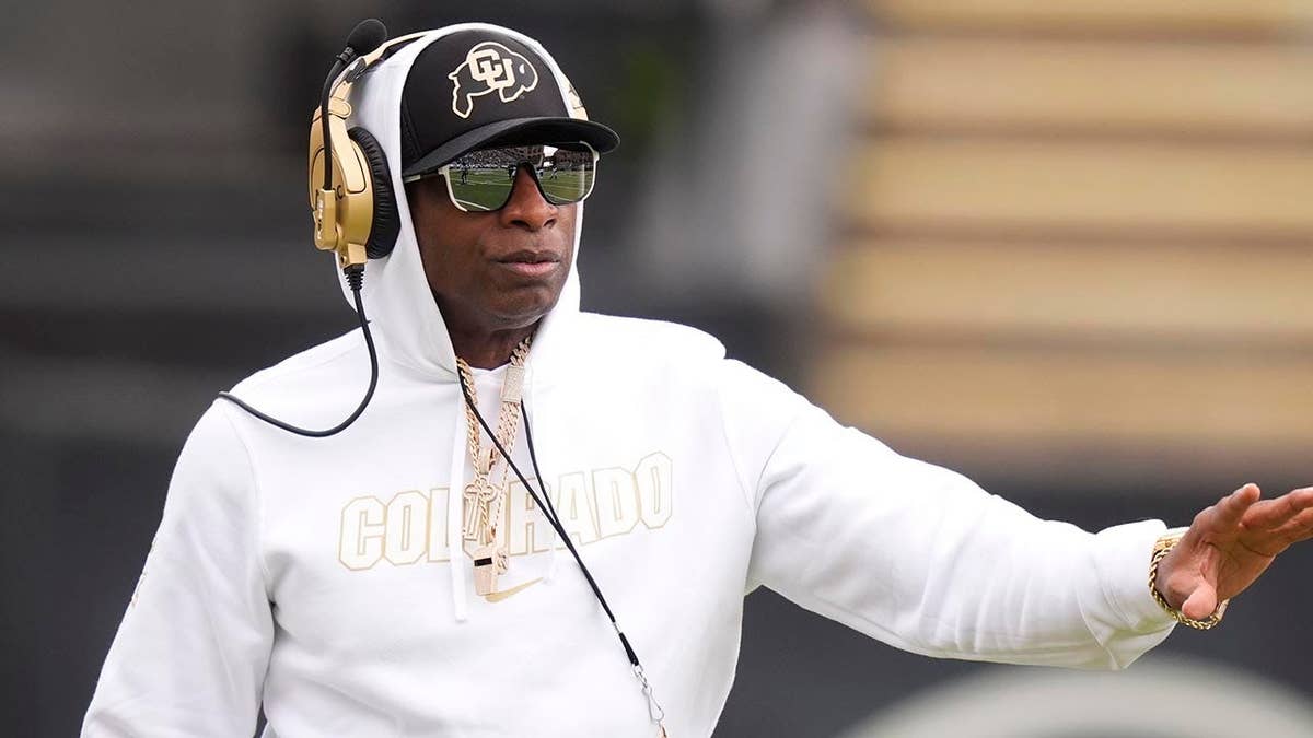 Colorado Buffaloes head coach Deion Sanders standing on the field at Folsom Field