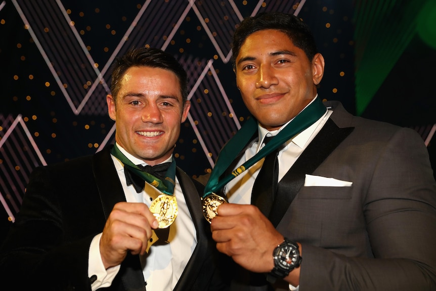 Cooper Cronk and Jason Taumalolo hold up their Dally M medals.