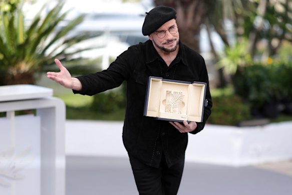 John Travolta with the honorary Palme d’Or he received after a screening of Propeller One-Way Night Coach at Cannes.