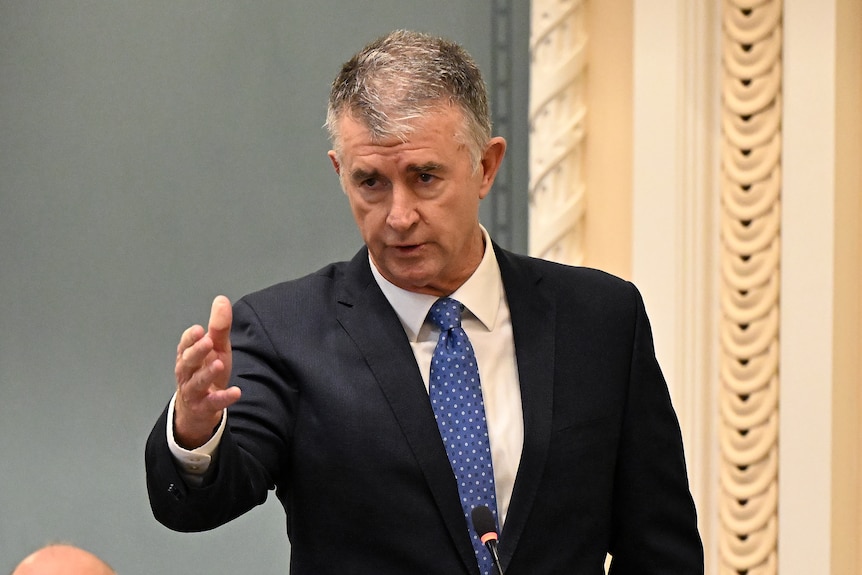 A man in a suit gestures