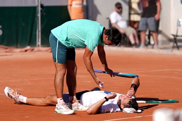 Mariano Navone congratulates a prone Jakub Mensik after the match.