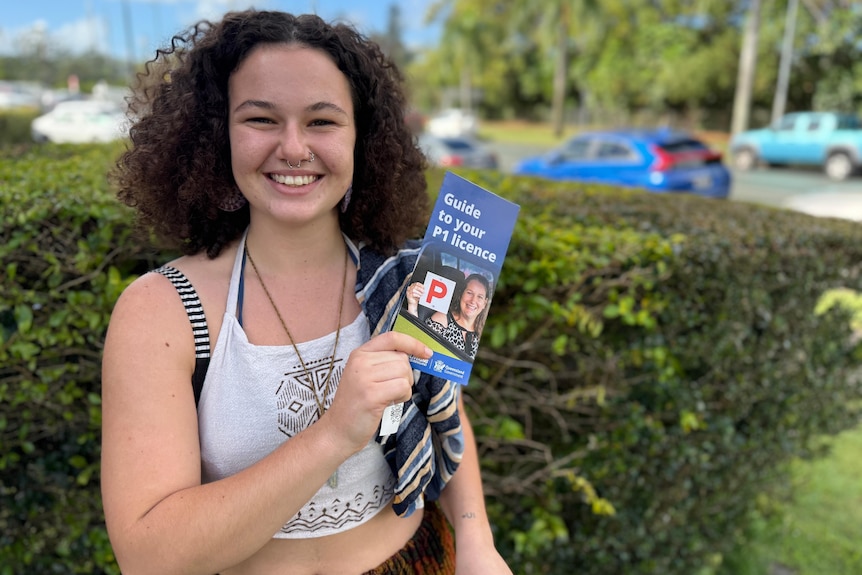 Smiling woman holding licence pamphlet