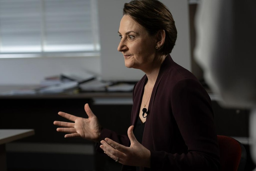 Minister Amber-Jade Sanderson gestures with her hands while speaking to a reporter