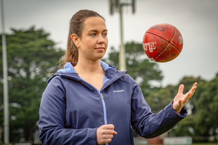 A woman handballing a football