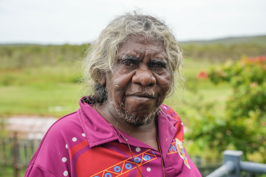 An Aboriginal woman with grey hair looking at the camera.