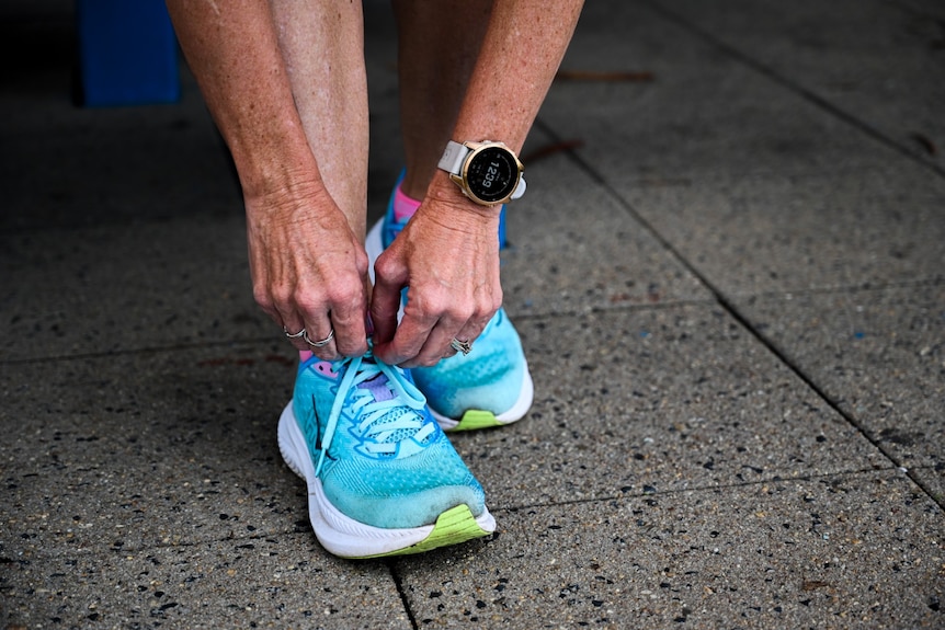 A close up of hands tying the laces up on a running shoe