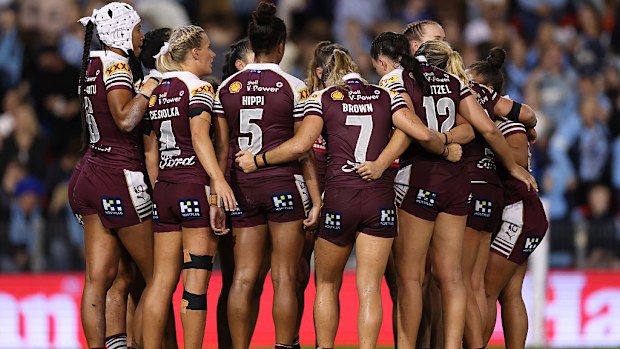 Queensland Maroons players huddle after a NSW try.