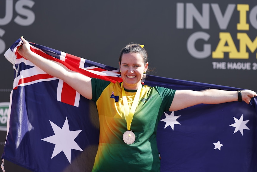 Vanessa Broughill holds an Australian flag with her medal