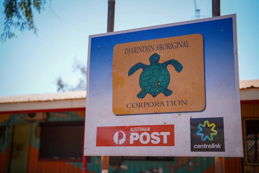 Close up of a colourful sign out the front of a building with turtle emblem, Australia post logo and Centrelink logo