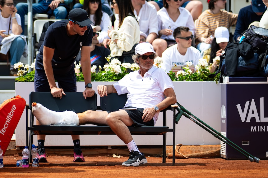 Francisco Roig rests his leg which is in a cast