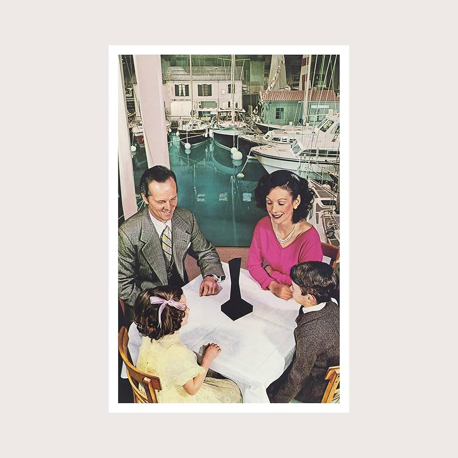 Album cover featuring a family sitting at a table looking at a strange black object.