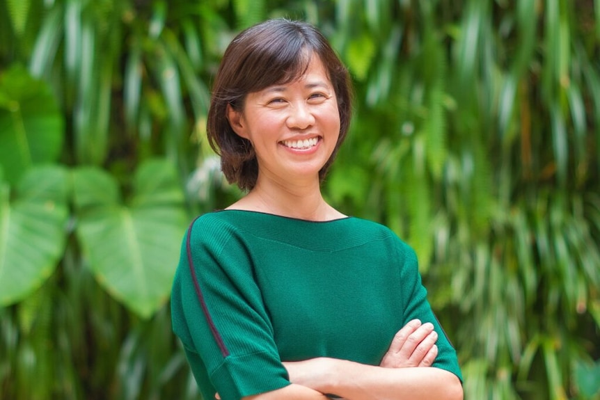 Ya-Yen Sun wearing a green top posing in front of a green, leafy background