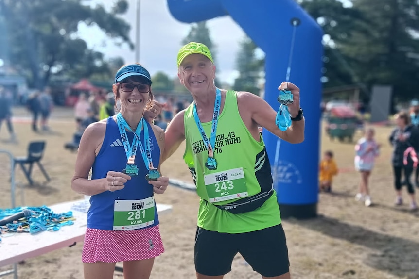 Two marathon runners standing next to each other.