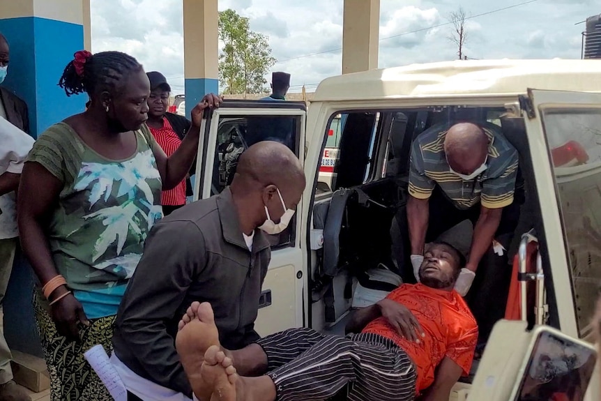 A man is carried from an ambulance as he arrives at Bunia General Referral Hospital following confirmation of an Ebola outbreak.