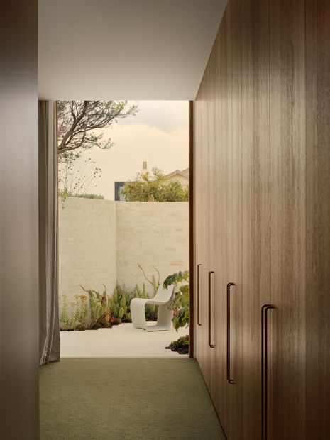 At the front, a private courtyard extends from the main bedroom, while garden walls and planting soften the boundary.