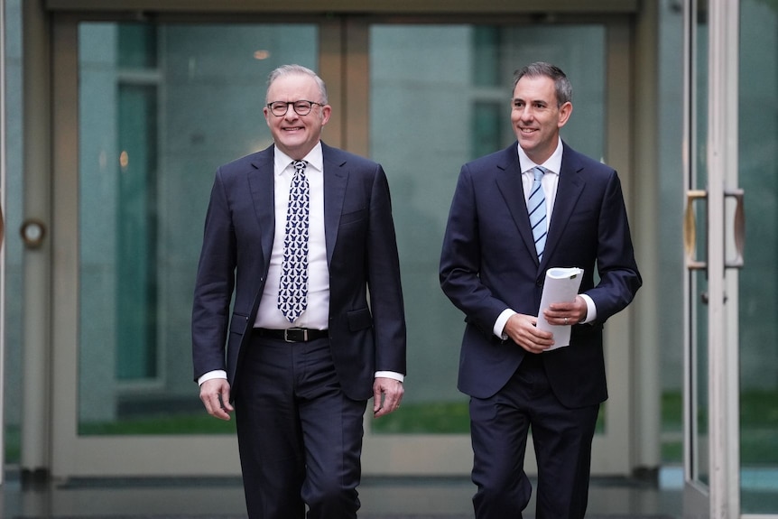 two male politicians walking through glass double doors