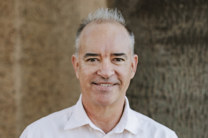 A smiling man with short, grey hair.