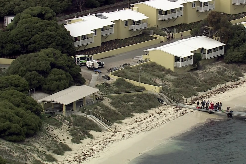 Police and paramedics surround someone on the jetty from afar