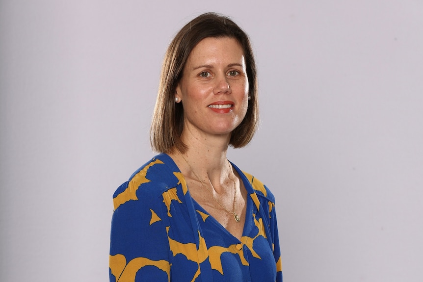 Headshot image of woman in blue and gold dress